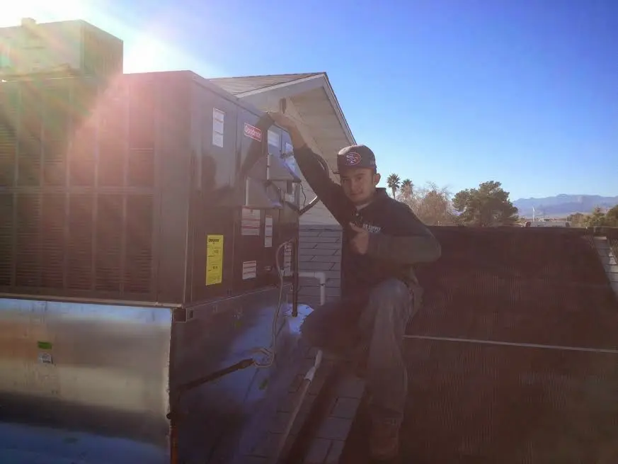 HVAC technician performing Boiler Repair on a rooftop unit in Moosic